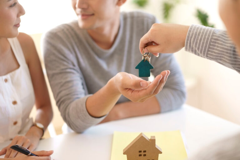 Casal recebendo as chaves do imóvel recém-adquirido.