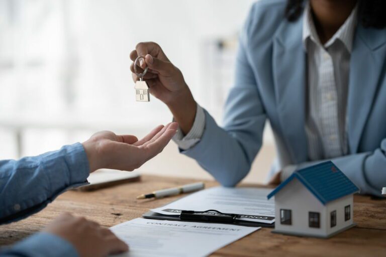 mulher segurando chaveiro com formato de chave e entregando para mãos de homem para representar leads para mercado imobiliário