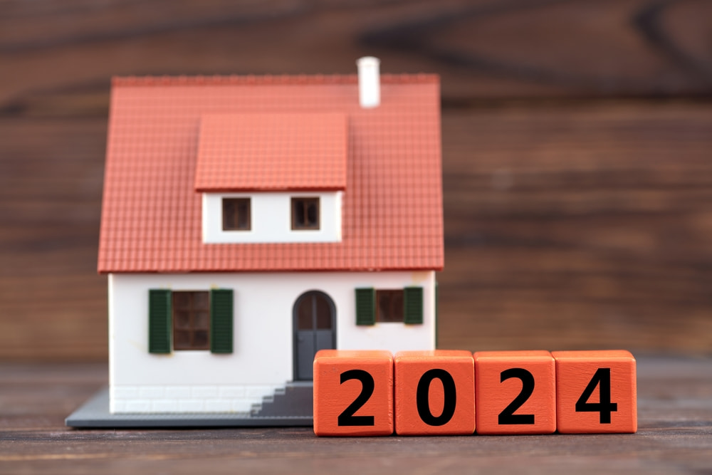 casa em miniatura com blocos de madeira à frente formando "2024" para representar as tendências de marketing imobiliário