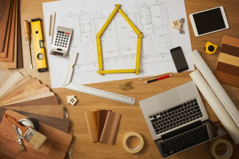 Equipamento de construção de imóveis em cima de uma mesa, além de um computador e tablet.