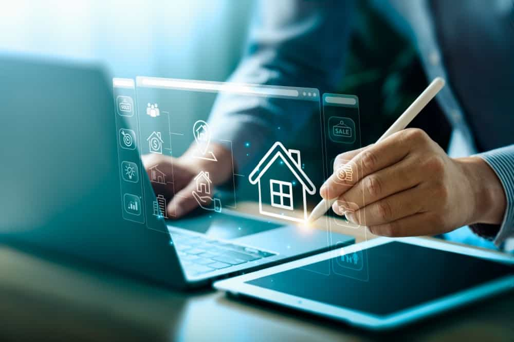 Homem com um notebook trabalhando junto a uma figura digital de casa.